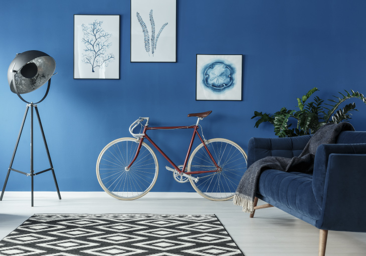 Picture of a beautifully painted blue room with a bicycle in it.